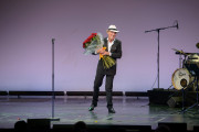 Michael Heltau auf der Bühne mit einem Blumenstrauß in der Hand