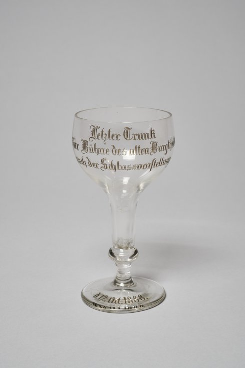 Trinkglas mit der Inschrift „Letzter Trunk auf der Bühne des alten Burgtheaters nach der Schlussvorstellung d. 12. Oct. 1888.“ (aus der Sammlung Hugo Thimig)