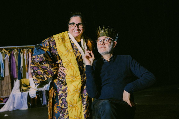 Maria Happel in einem gelben Probenkostüm neben Regisseur Herbert Fritsch mit einer Krone auf dem Kopf.