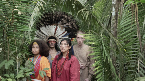 Drei Frauen in traditioneller Kleidung und ein Mann stehen im Amazonas-Dschungel