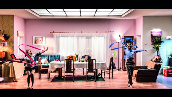 Blick in ein Wohnzimmer, zwei Frauen tanzen mit Gymnastikbändern